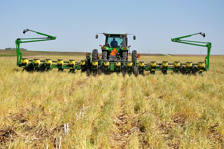 no till drill tractor in a field with crop residue